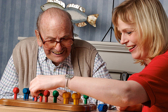 Frau Spielt mit älterem Mann ein Brettspiel