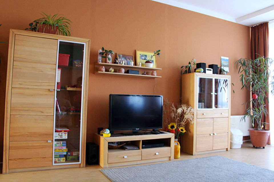 Teil des Wohnzimmers mit Schrank, Regal, Vitrine und Fernseher