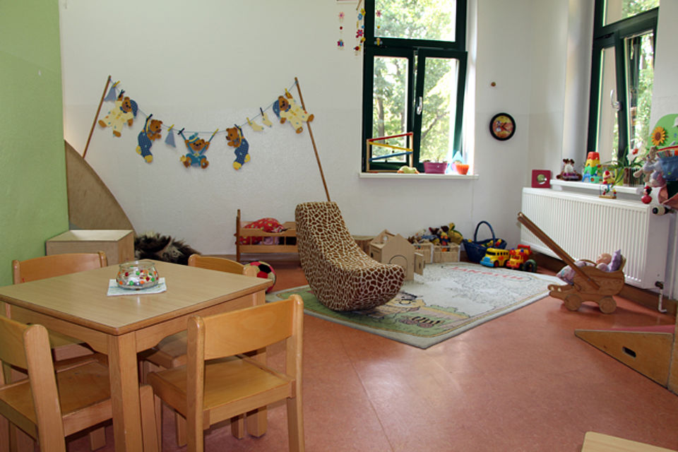 Im Gruppenraum befinden sich ein Wippsessel und diverses Spielzeug