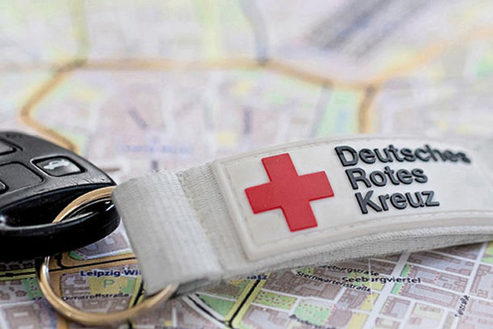 Autoschlüssel mit DRK-Anhänger liegt auf einem Stadtplan