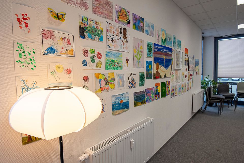 Wand mit vielen selbstgemalten Bildern