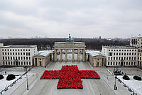 Viele Menschen formen vor dem Brandenburger Tor ein Rotes Kreuz
