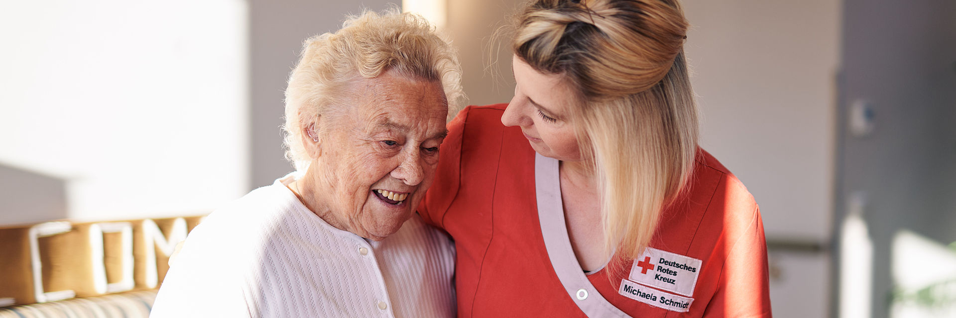 Pflegekraft stützt Seniorin