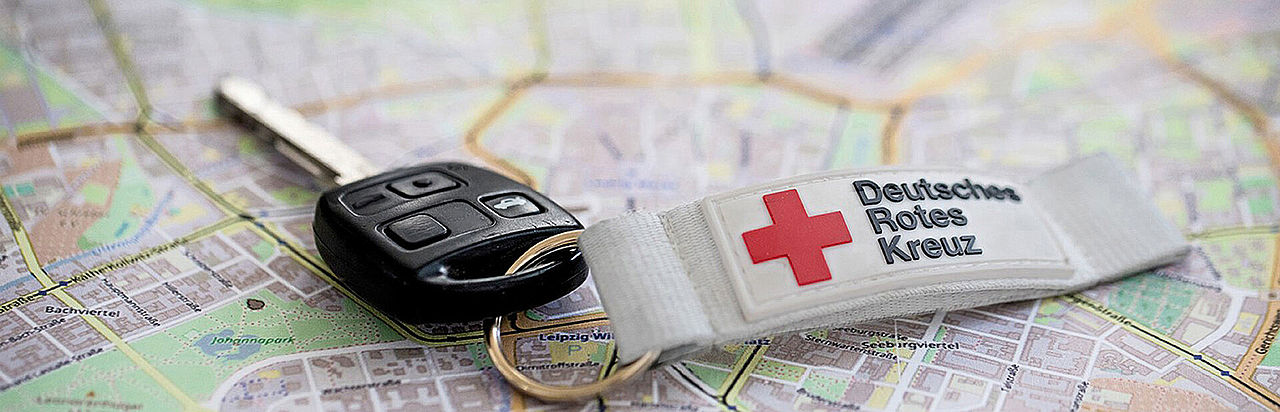 Autoschlüssel mit DRK-Schlüsselanhänger liegt auf einer Landkarte