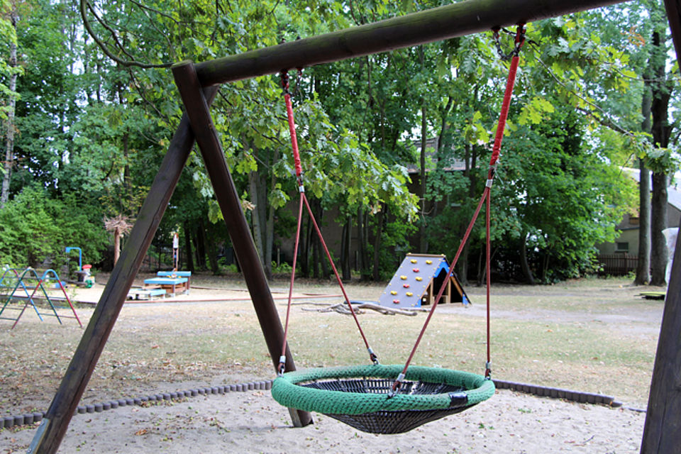 Garten mit Korbschaukel, Kletterelement und Sandkasten