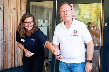 Frau Reibetanz und Olaf Hagenauer schneiden Feierlich ein rotes Band vor der Tür der Kita durch. Als Symbol der Eröffnung der neuen Kita