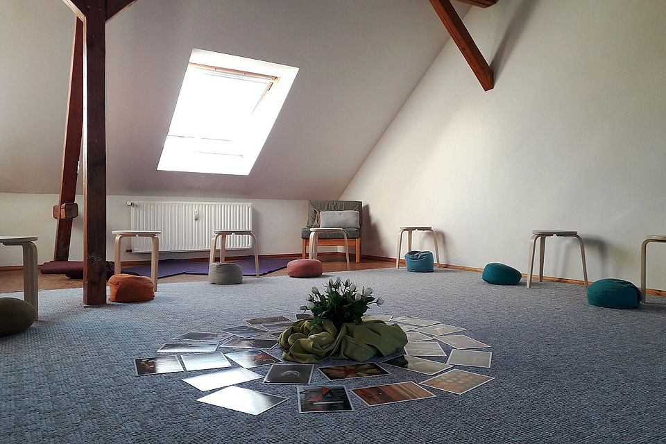 Raum im Dachgeschoss, der mit Hockern, Sitzkissen, Fotos ausgestattet ist