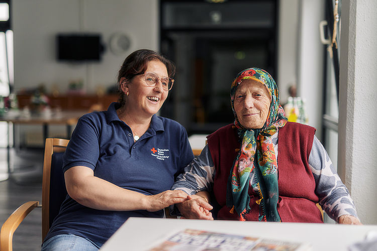 Betreuerin unterhält sich mit älterer Dame