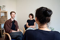 zwei Personen sitzen einer weiteren gegenüber