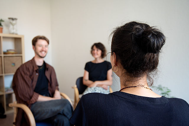 zwei Personen sitzen einer weiteren gegenüber