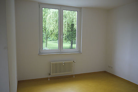 leeres Wohnzimmer, ebenerdig, mit Blick Richtung Fenster