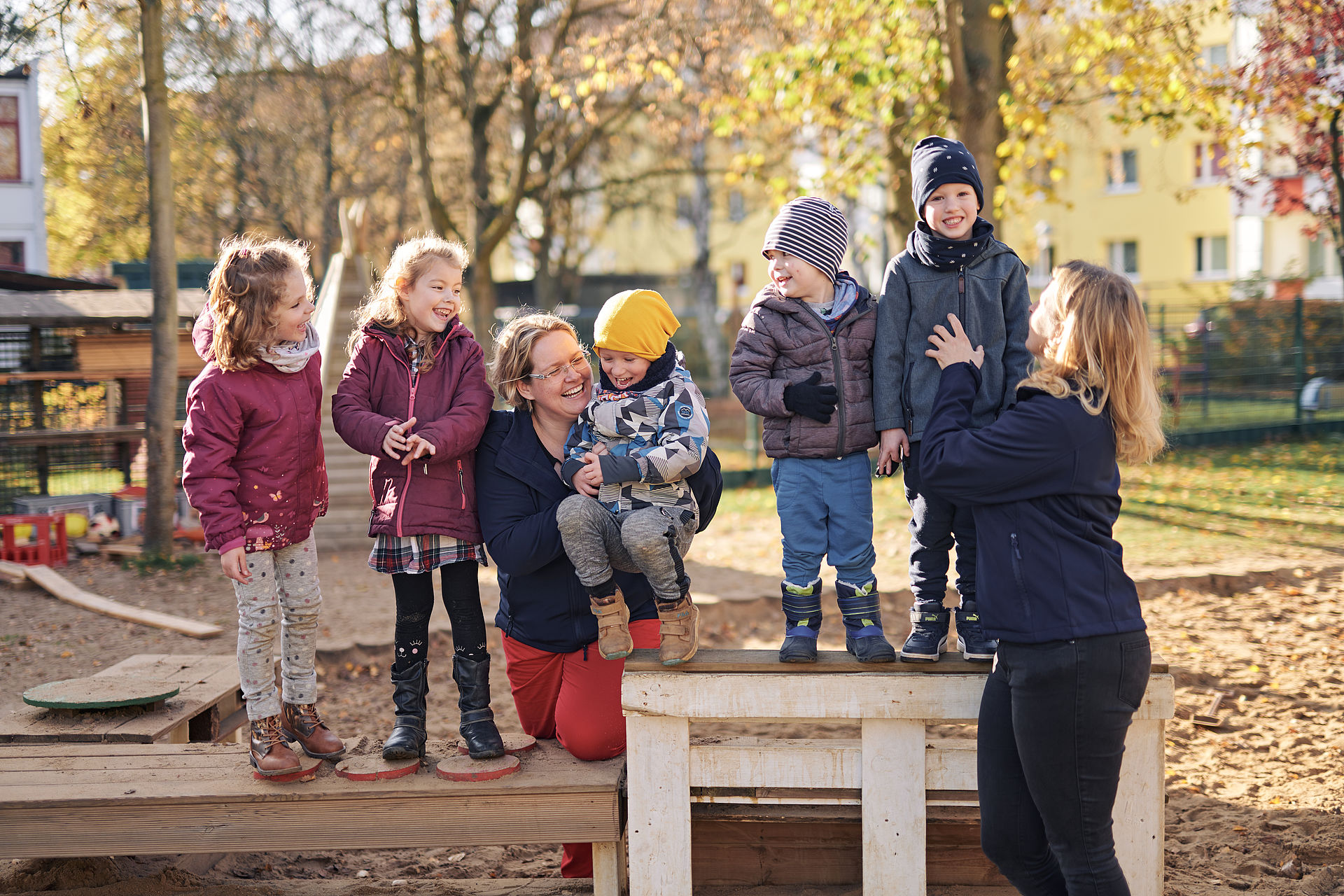 Erzieherinen und Kinder beim Spielen im Garten der KiTa