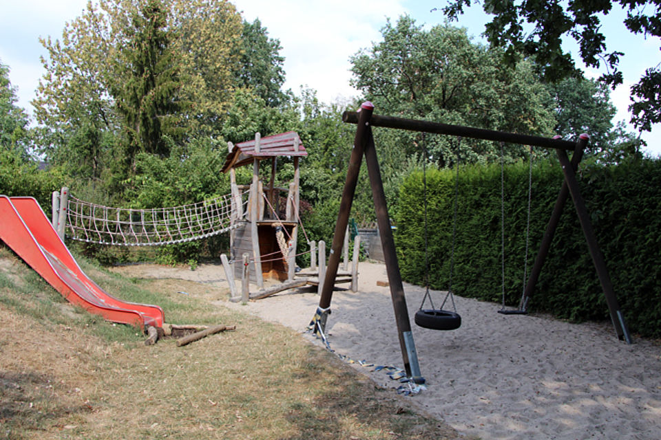 Garten mit Schaukeln, Rutsche und Kletterturm