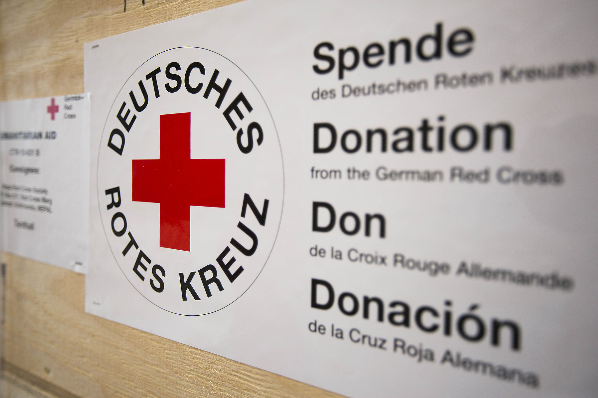 Versandkiste mit großem Aufkleber mit DRK-Logo und Spendenhinweis