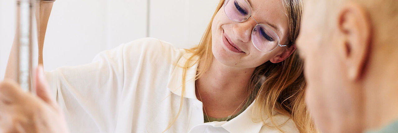 Eine Betreuerin im Therapieraum mit einem Bewohner