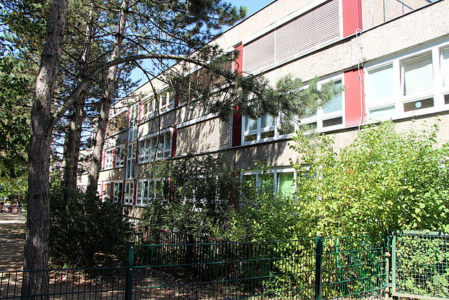 Gebäude in Plattenbauweise mit Bäumen davor