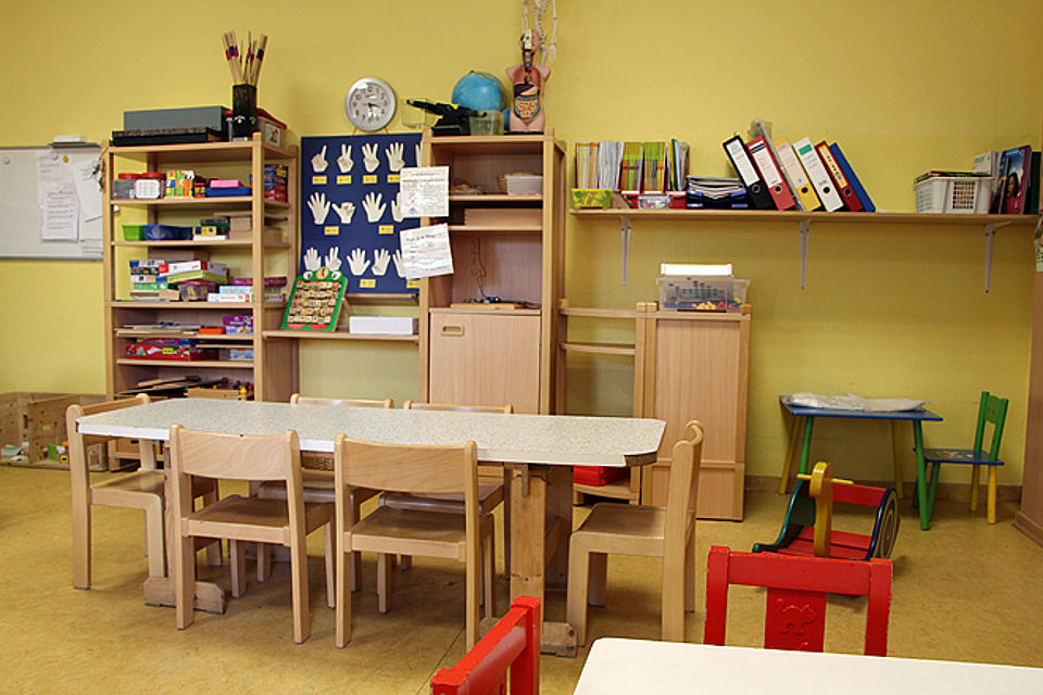 Gruppenzimmer mit Tisch, Stühlen und Regalen